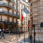 Charming Paris street with French flag and classic architecture.