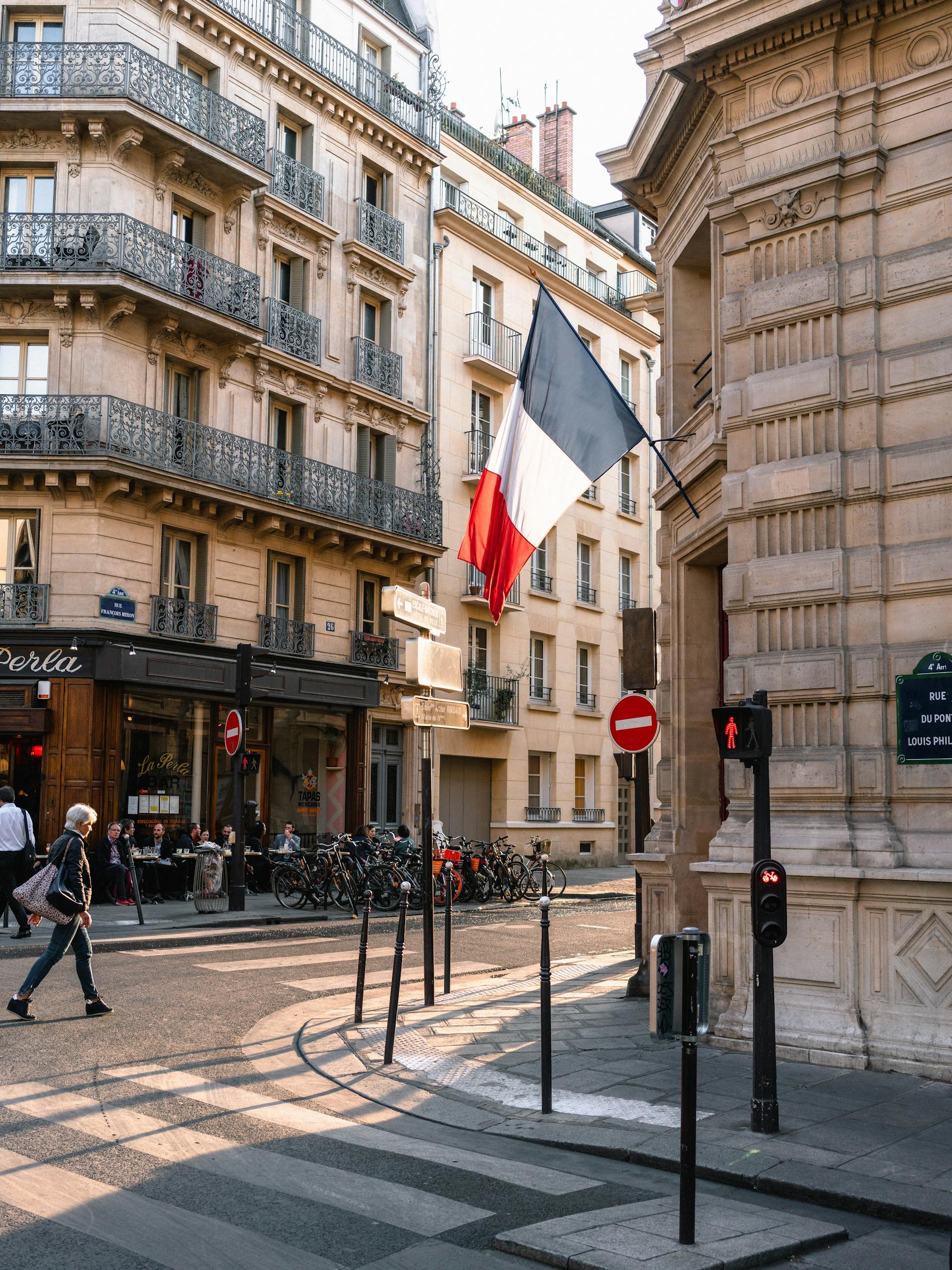Charming Paris street with French flag and classic architecture.