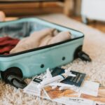 Close-up of an open suitcase with travel essentials like passport and tickets, ready for a journey.